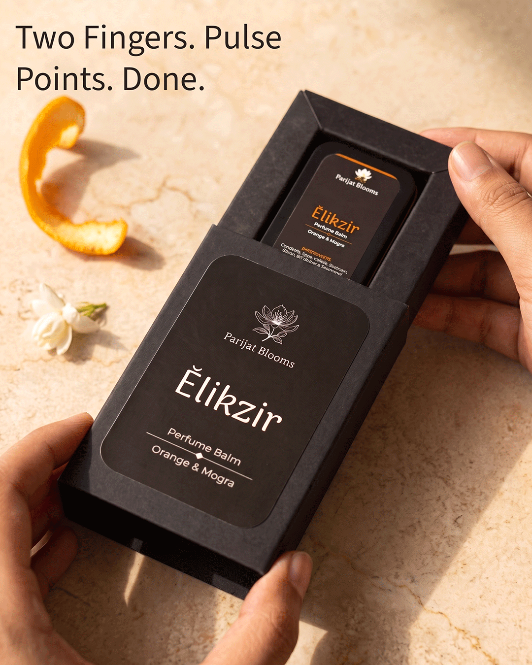 Elikzir Orange Mogra Perfume Balm Ayurvedic ritual perfume balm in use — hand holding perfume balm Parijat Blooms India